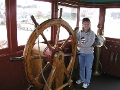 Mhila at the wheel of the Eureka, Hyde Street Pier, San Francisco